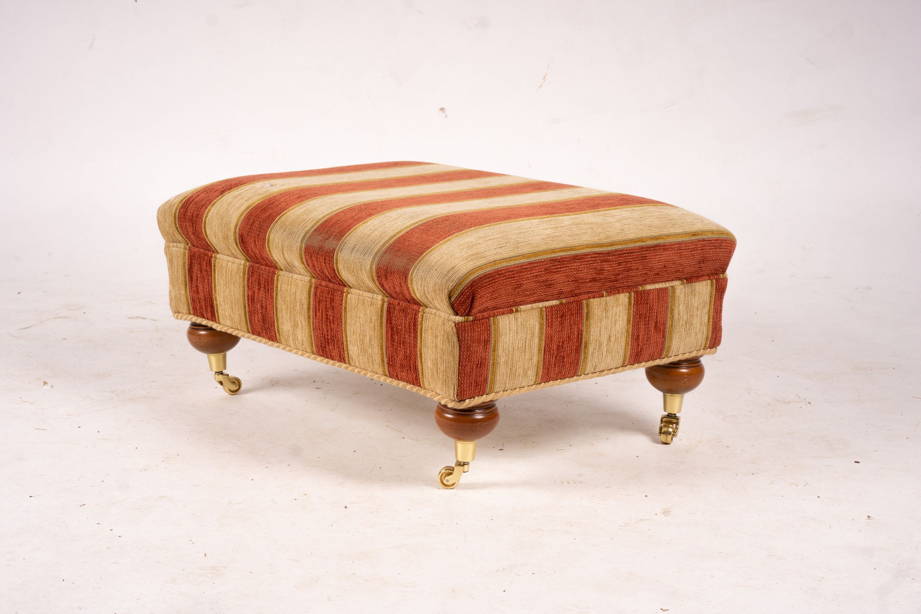 A pair of Duresta armchairs, width 94cm, depth 90cm, height 90cm and matching footstool in striped red and gold fabric